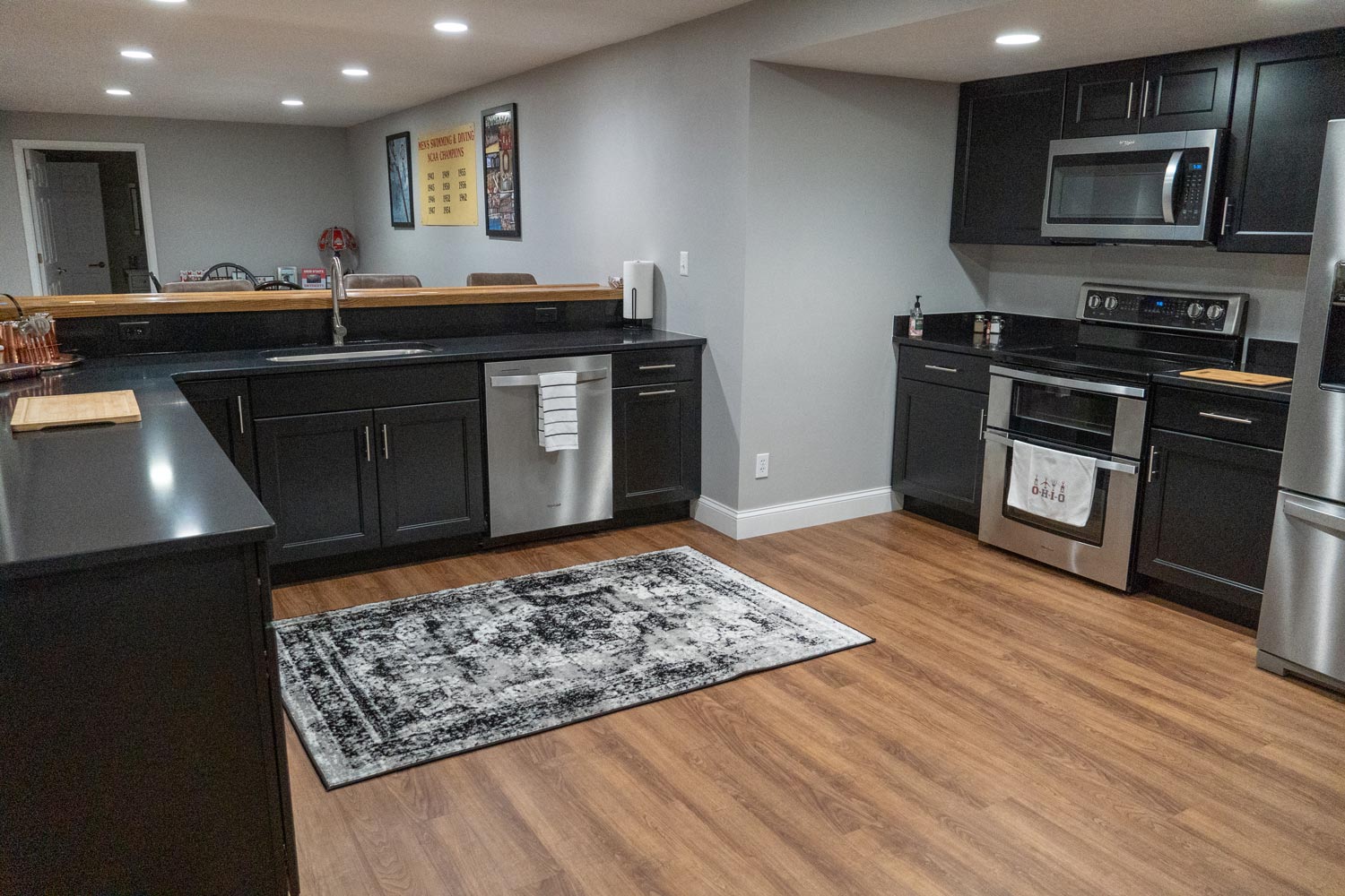 basement kitchen and bar with vinyl plank flooring and custom countertops